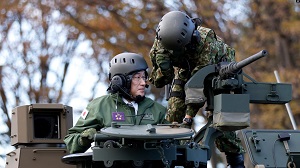 Perdana Menteri Jepang Fumio Kishida, kiri, mengendarai tank Japan Ground Self-Defense Force (JGSDF) Type 10 saat meninjau JGSDF Camp Asaka di Tokyo, Jepang, Sabtu, 27 November 2021. (Foto: AP)