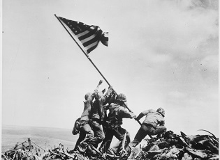Gambar Utama: Marinir AS mengibarkan bendera kedua di puncak Gunung Suribachi di Iwo Jima, 23 Februari 1945. (Gambar: Administrasi Arsip dan Catatan Nasional, WC 1221.)